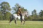 man rides Appaloosa-Mix