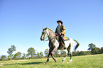 man rides Appaloosa-Mix