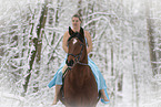 Woman riding through the snow in a dress