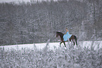 Woman riding through the snow in a dress