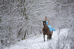 Woman riding through the snow in a dress