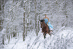 Woman riding through the snow in a dress