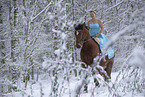 Woman riding through the snow in a dress