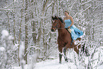 Woman riding through the snow in a dress