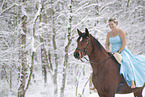 Woman riding through the snow in a dress
