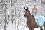 Woman riding through the snow in a dress