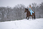 Woman riding through the snow in a dress