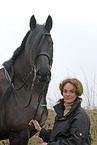 young woman with friesian horse