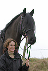 young woman with friesian horse