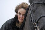 young woman with friesian horse