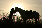woman with horse at sundown
