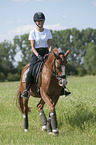 junge Frau reitet Deutsches Reitpony